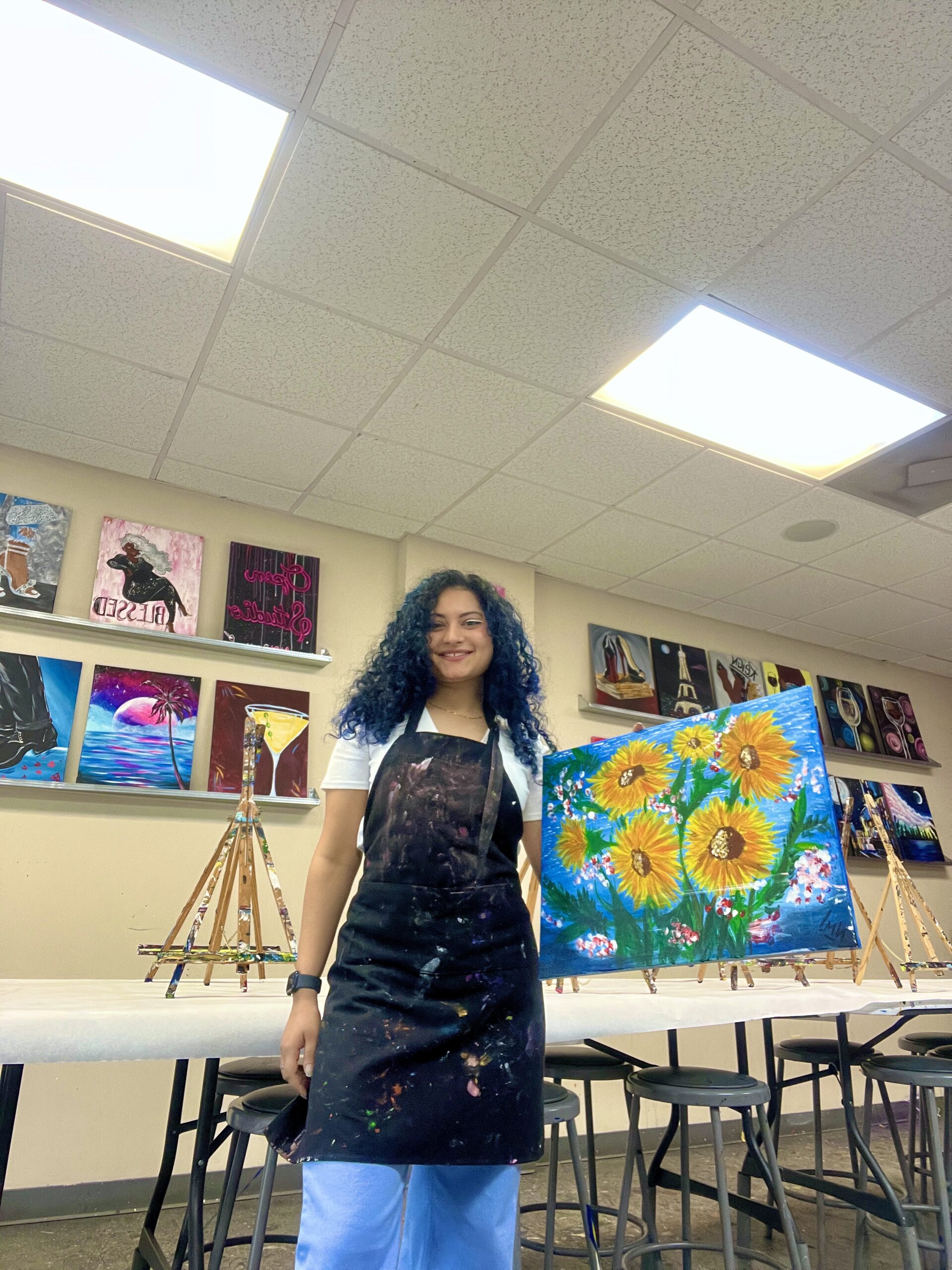 Woman holding painting at sip and paint class in Savannah Georgia